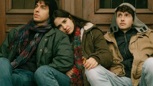 Drei Jugendliche sitzen vor einer Tür, Filmstill "Delegation"